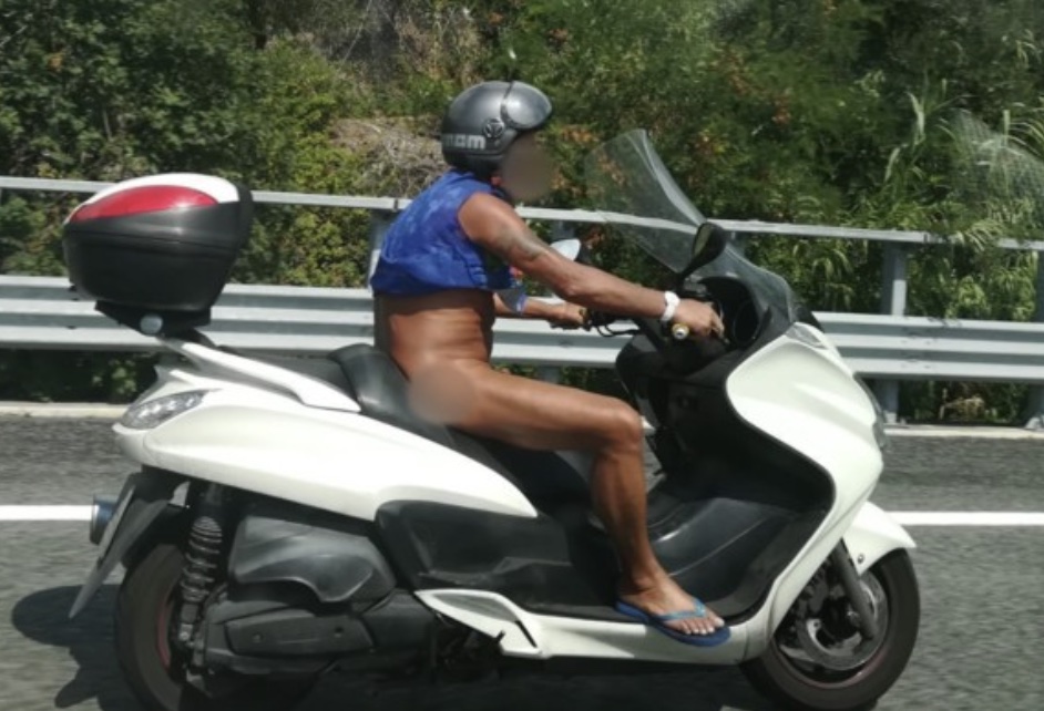 Uomo nudo mentre guida il suo scooter 